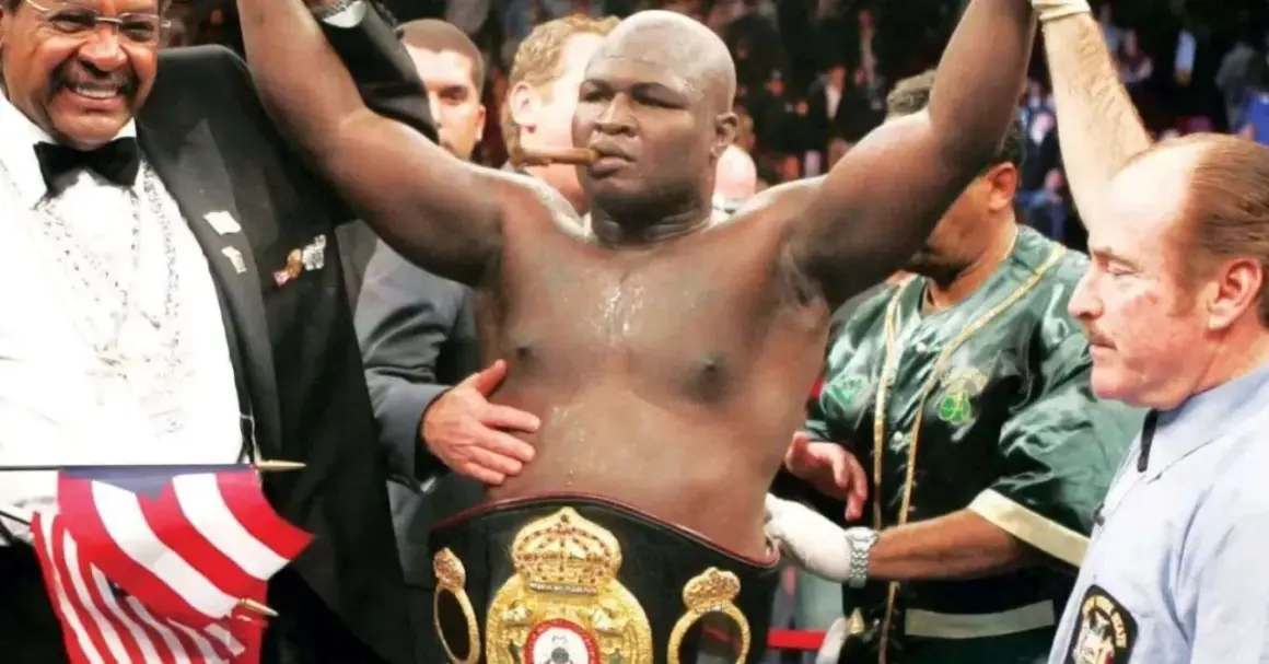 Boxer James Toney, with a cigar in his mouth and championship belt, celebrates a victory. His impressive **James Toney record** speaks for itself.