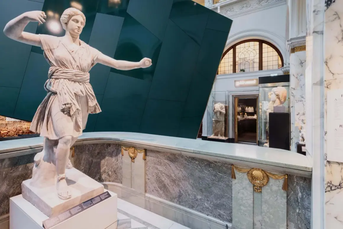Antik staty i ett bra museum i Stockholm. Marmor och en grön vägg skapar en dramatisk bakgrund.