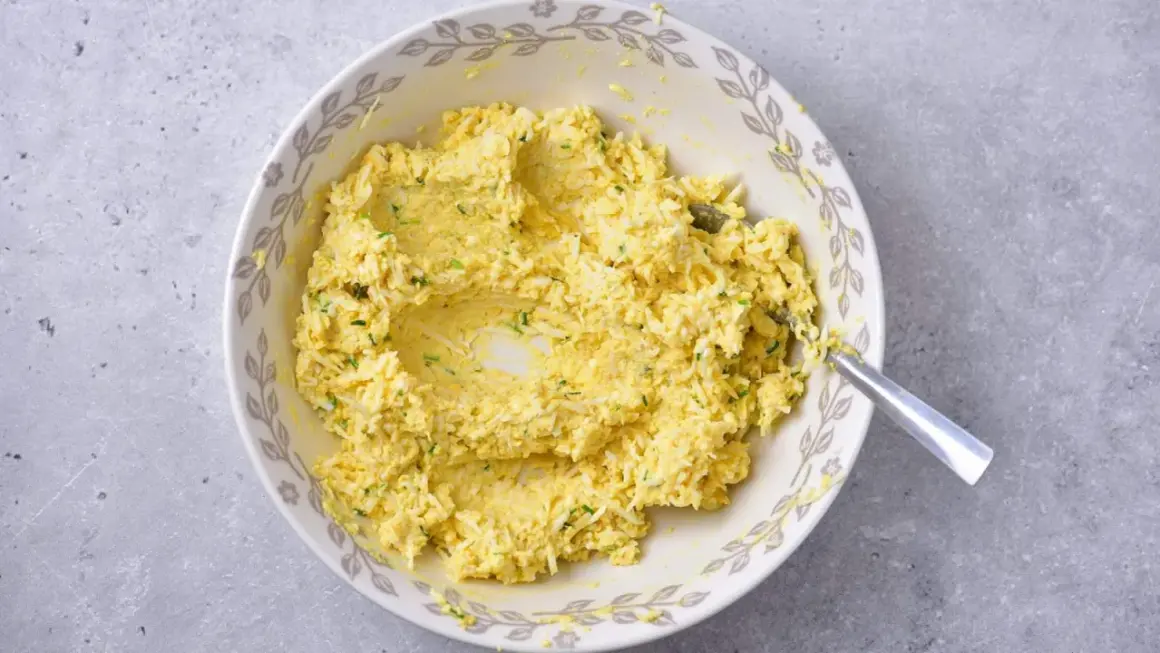 Mieszanka jajeczna z ziołami, przygotowana jako pasta jajeczna bez majonezu, w misce z ozdobnym brzegiem.
