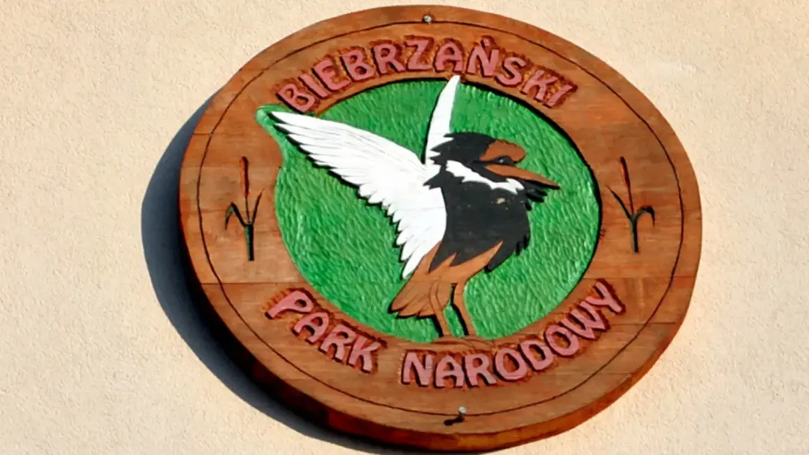 Drewniany symbol Biebrzańskiego Parku Narodowego z ptakiem i napisem.