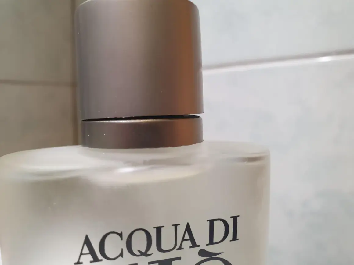 Szklana butelka z napisem ACQUA DI GIO 100ml, z metalową nakrętką.