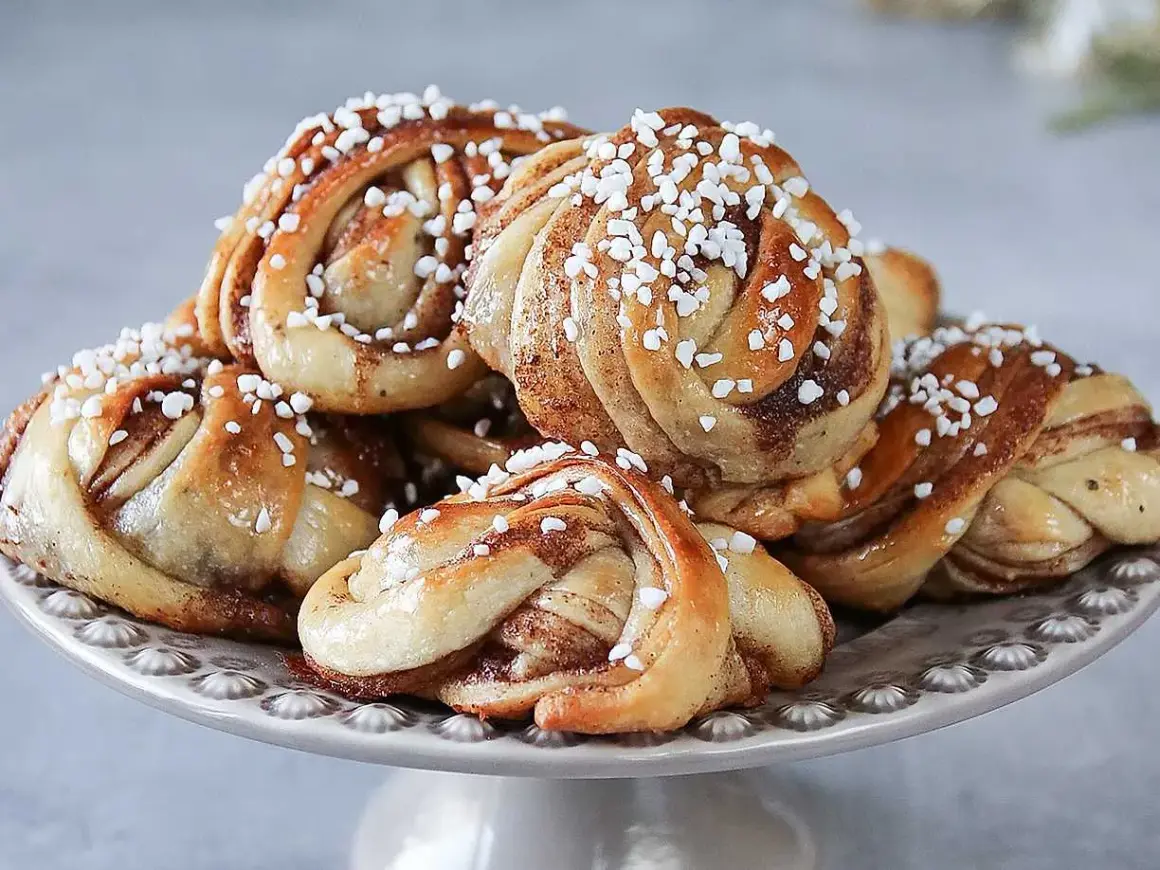 En hög med nybakade kanelbullar, perfekta för ett kanelbullar recept. Strösslade med pärlsocker.