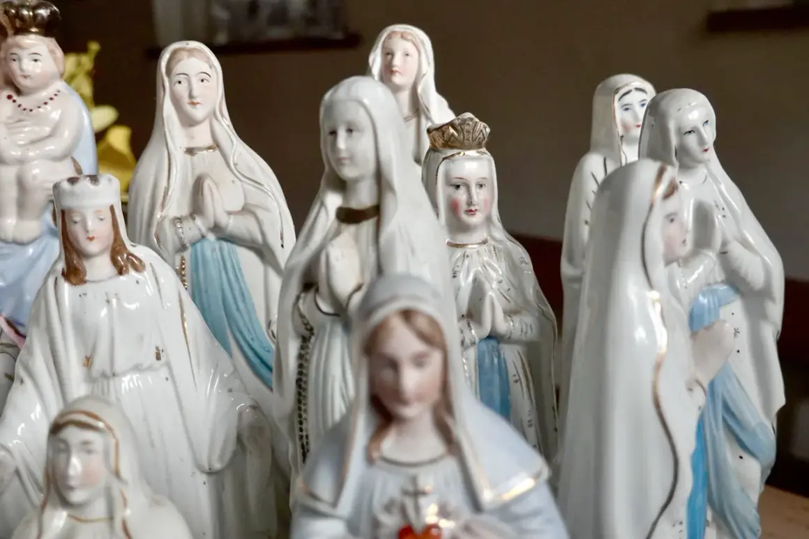 Eine Sammlung von Marienfiguren, die an das maria geburt datum erinnern. Die Figuren tragen weiße Gewänder und einige haben Kronen.