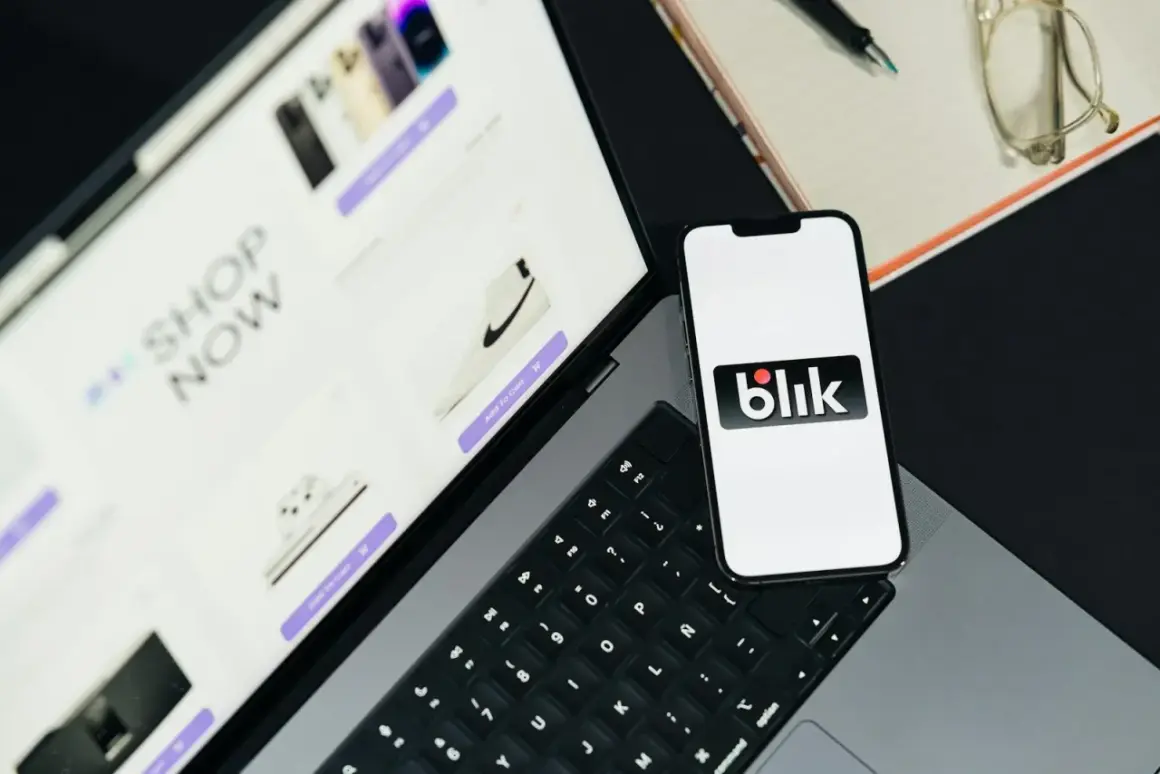 Na ekranie telefonu widnieje logo Blik. Obok leży tablet z ofertą zakupów online, pokazujący buty i elektronikę. Takie dane widzi odbiorca przelewu na telefon.