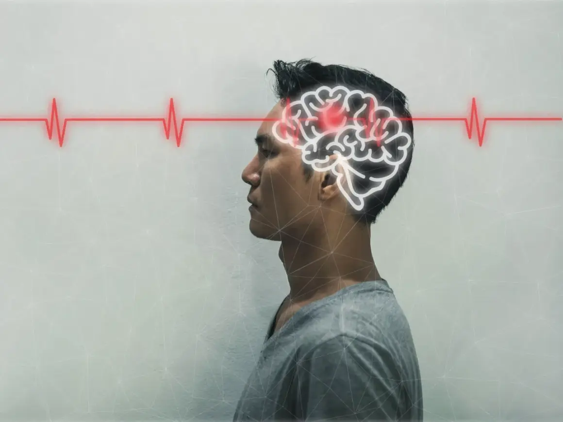 Mężczyzna z konturem mózgu i czerwoną linią EKG, symbolizującą jego stan.