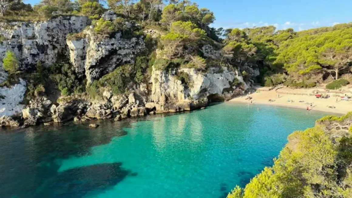 Aguas turquesas bañan las calas en Vera, rodeadas de acantilados rocosos y pinos frondosos. Un paraíso mediterráneo.