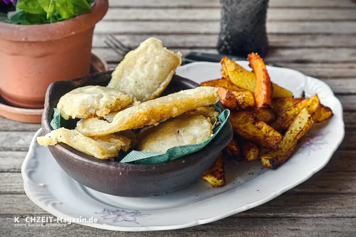 Knusprige Fischstücke in Tempurateig, daneben Pommes Frites. Ein Genuss, der zeigt, was ist Tempurateig.
