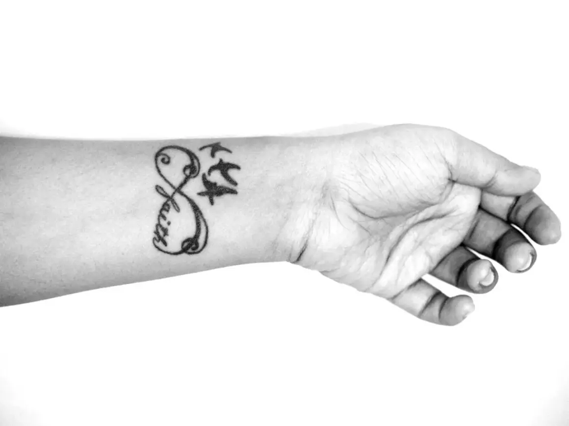 Ein beliebtes Tattoo für Frauen: Ein Unendlichkeitszeichen mit dem Wort "Faith" und drei fliegenden Vögeln auf dem Handgelenk.