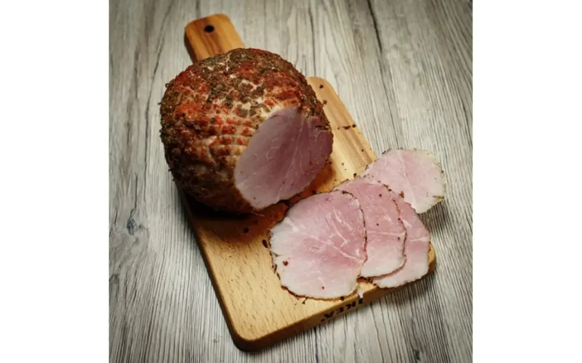 Wędzonka na desce, pokrojona w plastry. Idealna temperatura mięsa w środku podczas wędzenia to klucz do sukcesu.