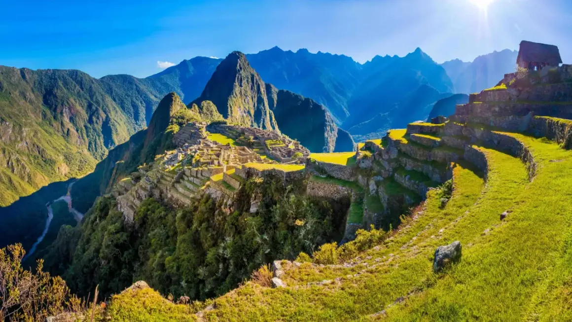 Machu Picchu w Peru, z tarasami i górami w tle. Planując podróż, warto pamiętać o **peru szczepienia**.