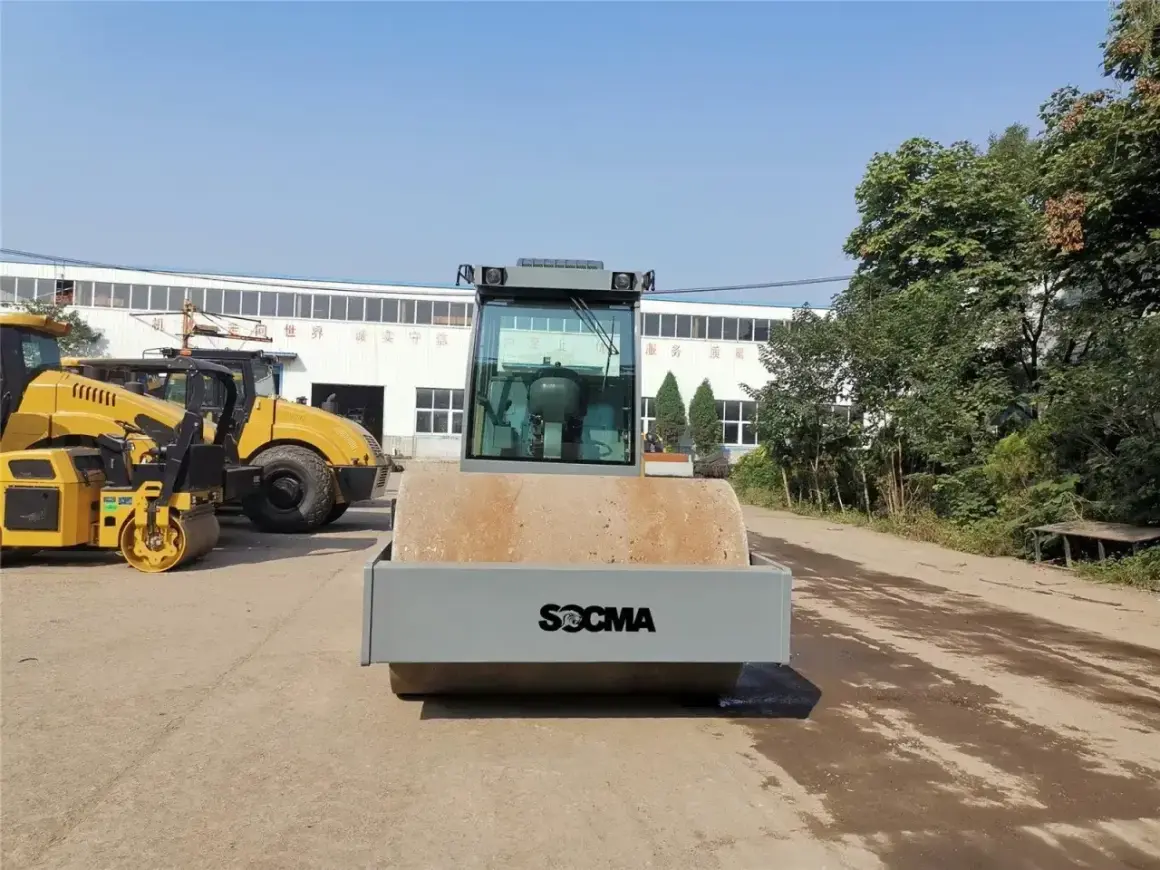 Nowe maszyny do robót ziemnych, w tym walec drogowy SOCMA, czekają na pracę.