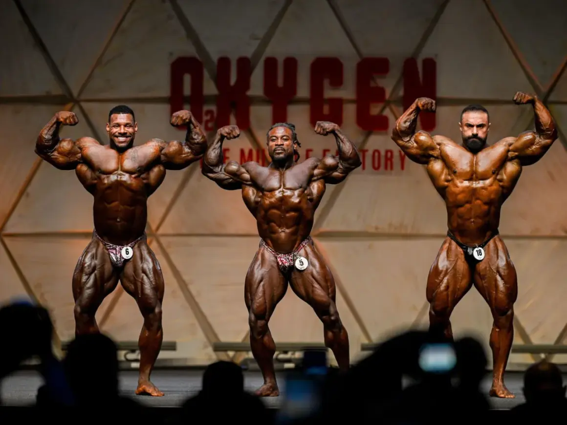 Drei Bodybuilder präsentieren ihre Muskeln auf der Bühne des Mr. Olympia Open.