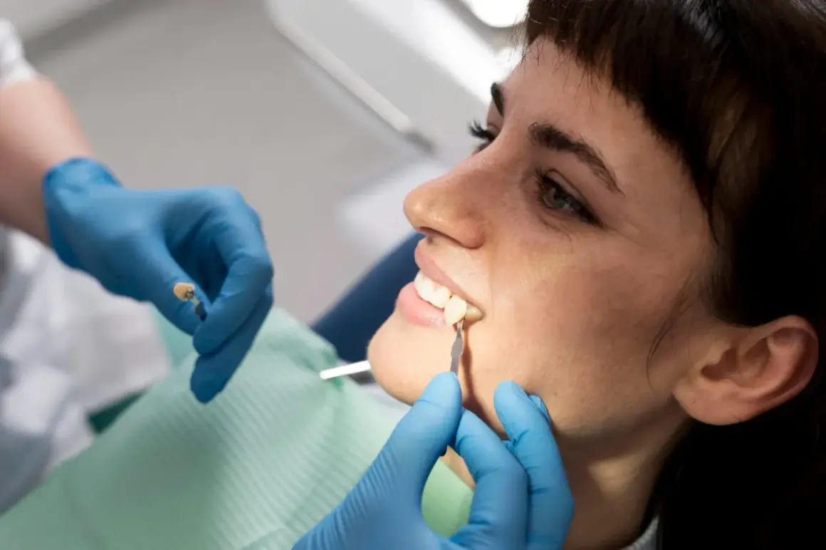 Dentysta dopasowuje kolor porcelany do lekko ukruszonego zęba. Cena zabiegu zależy od materiału.