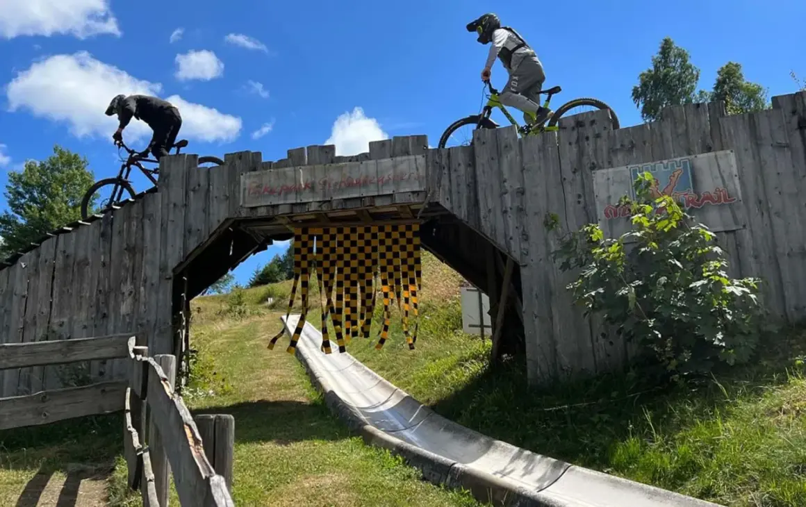 Två cyklister på en träbro i en bikepark i Tyskland. En perfekt plats för en äventyrlig semester.