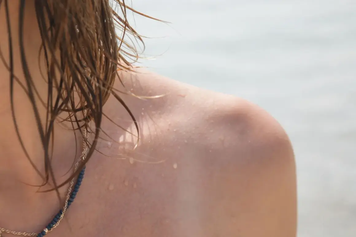 Schulter mit Wassertropfen und nassem Haar. Warum werde ich nicht braun?