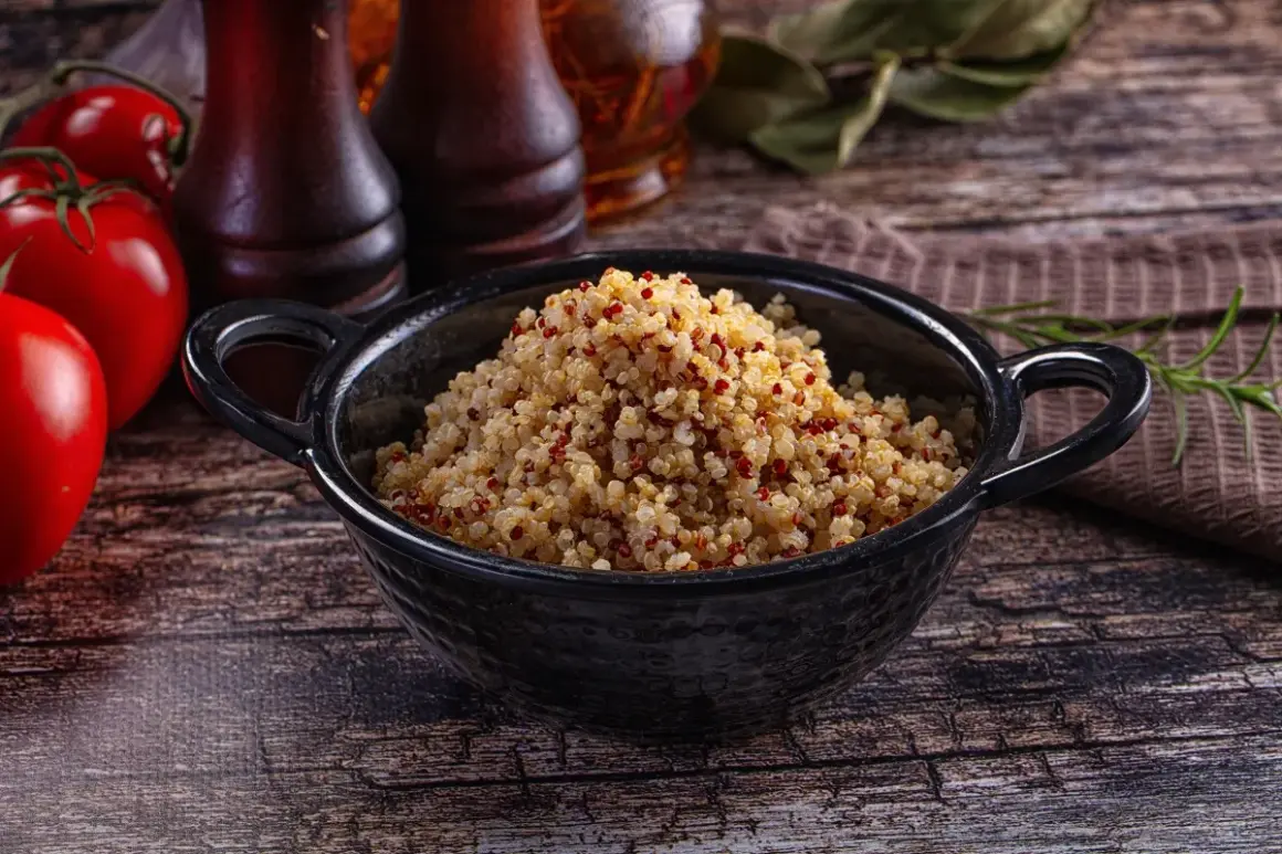 Quinoa cotta in una ciotola nera, pronta per essere gustata. Ecco come cuocere la quinoa per un piatto sano e gustoso.