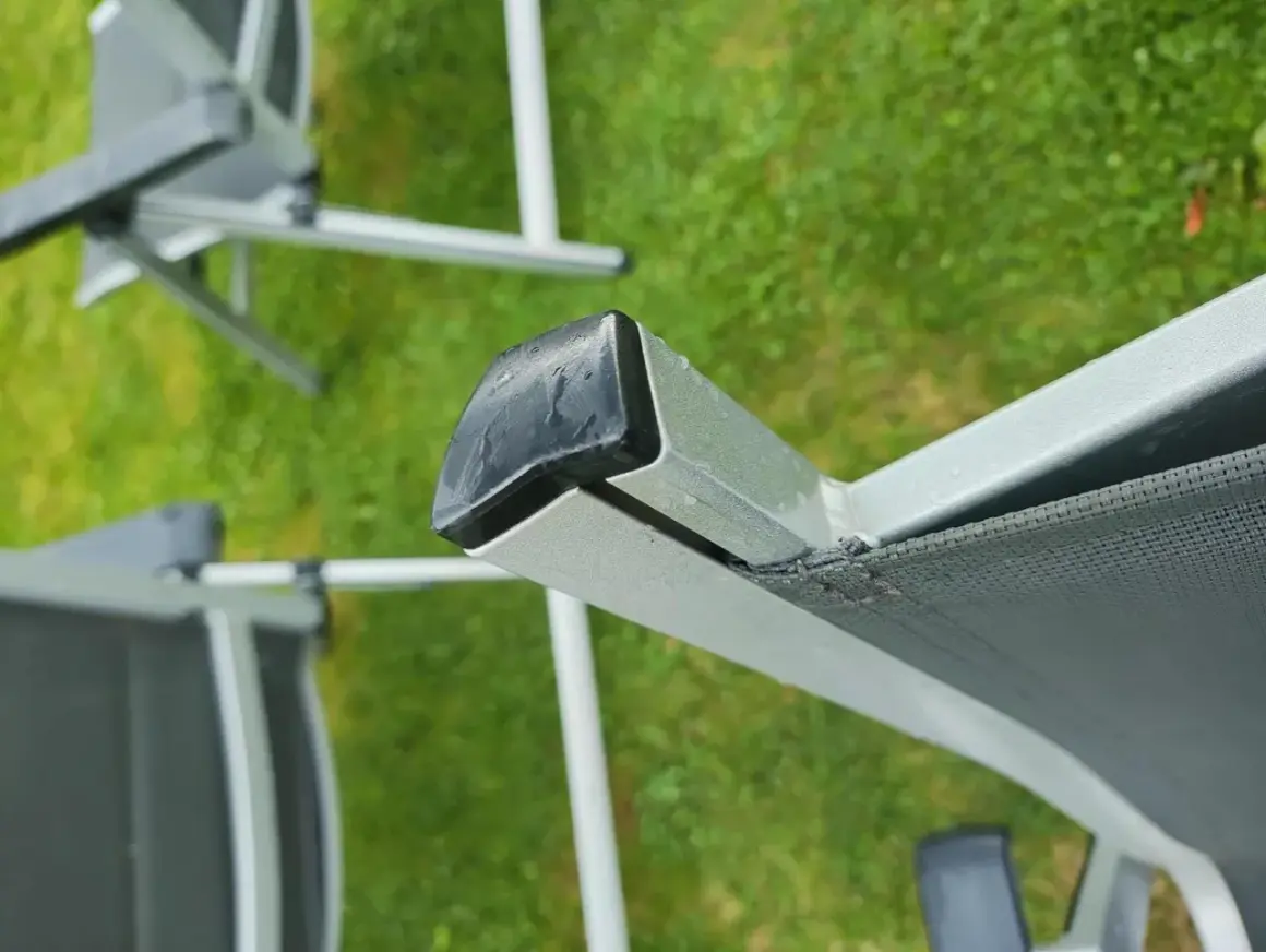 Nahaufnahme eines beschädigten Gartenstuhl PVC Bespannung. Die Reparatur ist dringend nötig, um den Stuhl wieder nutzbar zu machen.