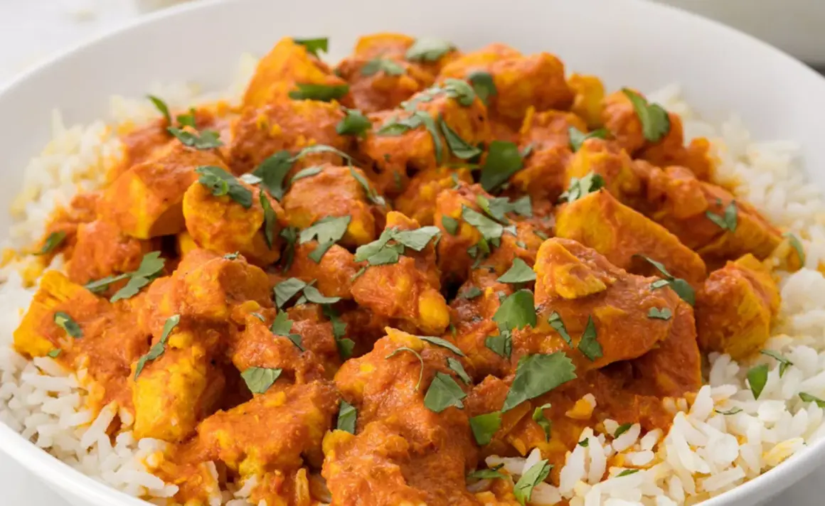 En skål med fluffigt ris toppad med saftig kyckling i en krämig, orange currysås. Strössel av färsk koriander ger en härlig touch till denna skolans kyckling curry.