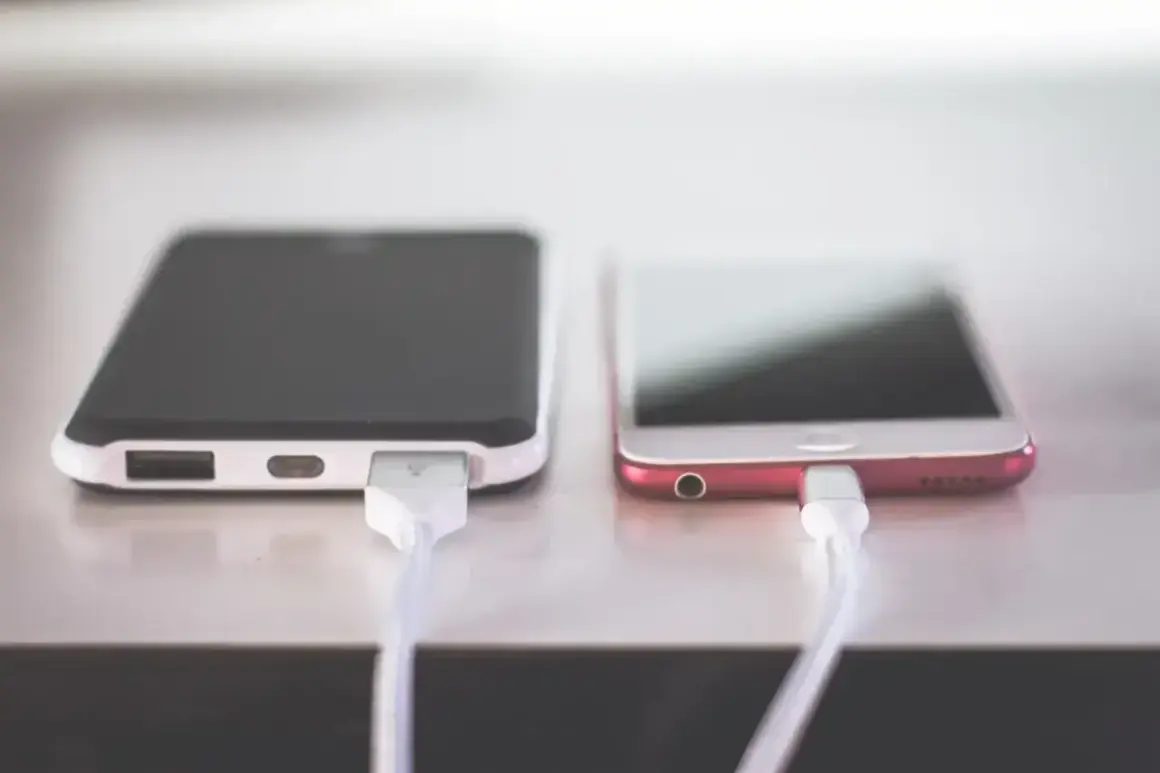 Dwa telefony podłączone do ładowania. Zastanawiasz się, dlaczego telefon wolno się ładuje? Może to wina kabla lub ładowarki.