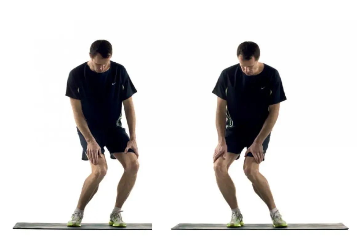 Homme effectuant un exercice de renforcement du genou, en position accroupie avec les mains sur les genoux.