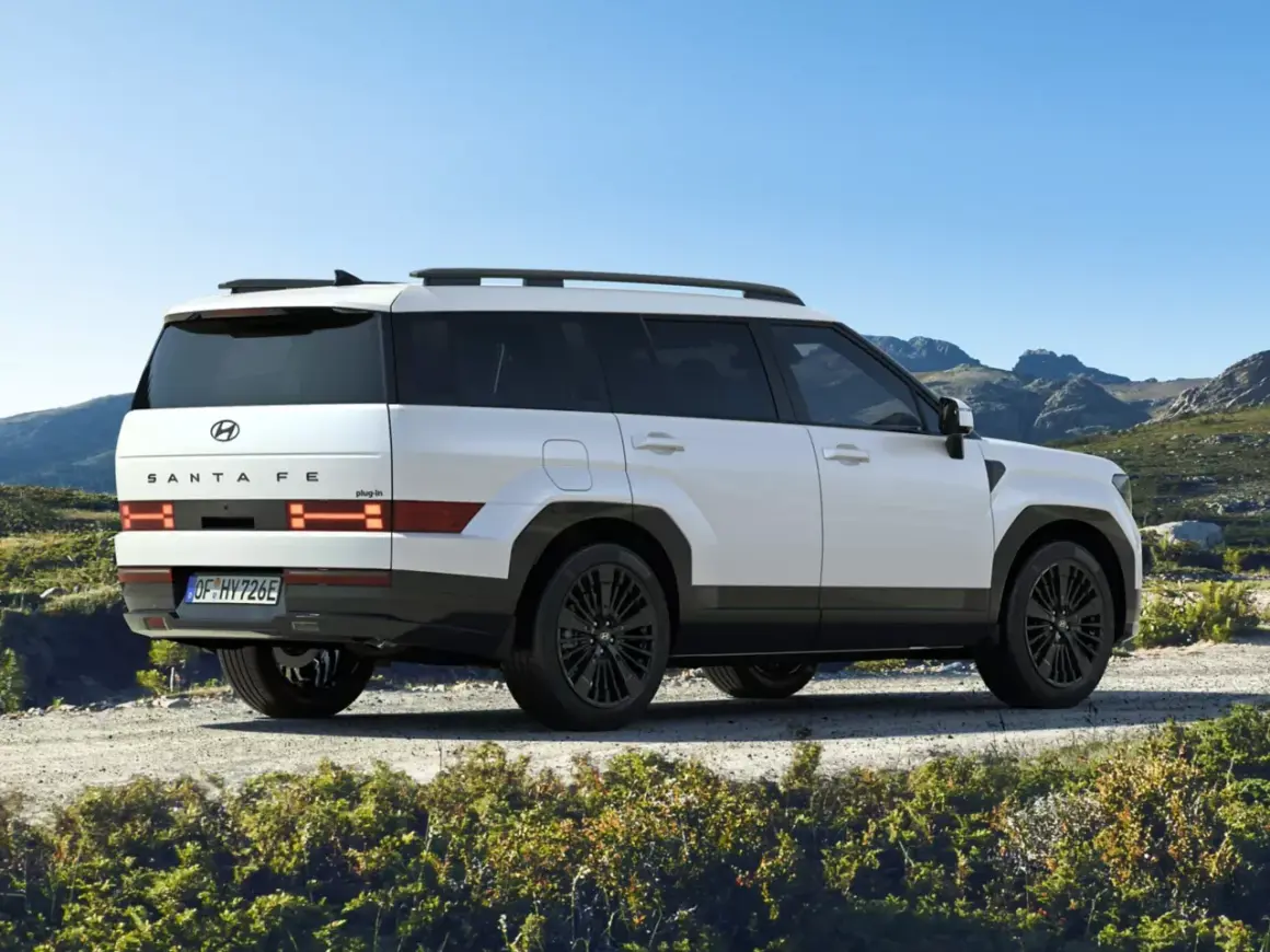 Biały Hyundai Santa Fe 2025 z czarnymi felgami na tle górskiego krajobrazu.
