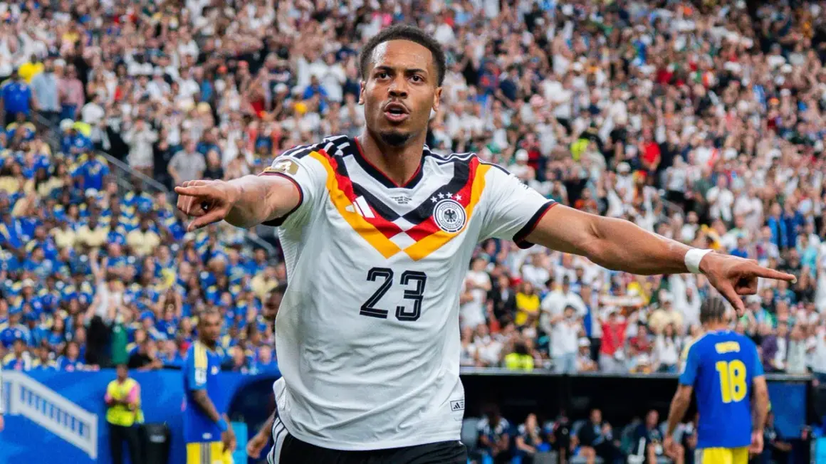 Fußballer Felix Nmecha im Deutschland-Trikot mit der Nummer 23, jubelt vor einer Menge.