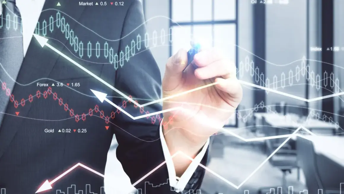 Biznesmen rysuje wykresy giełdowe i analizuje dane finansowe.