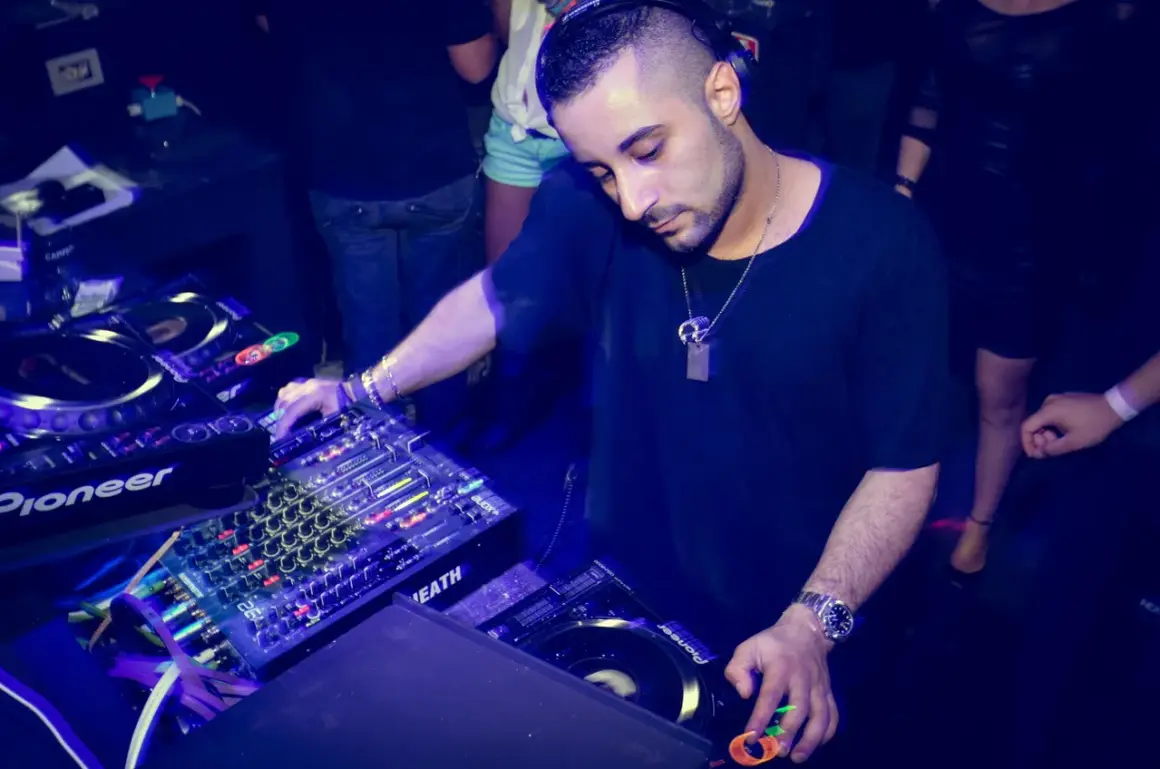 Un dj musica techno con cuffie mixa su console Pioneer, immerso nell'atmosfera di un club.