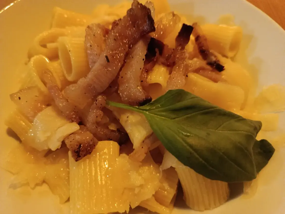 Makaron z chrupiącym guanciale, parmezanem i listkiem bazylii. To właśnie guanciale nadaje daniu wyjątkowy smak.
