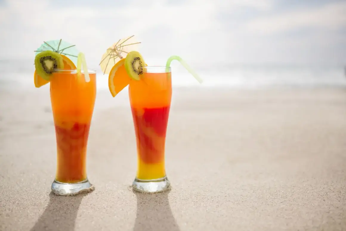 Dwa drinki na plaży, idealne na malibu sunrise. Orzeźwiające kolory i tropikalne owoce.