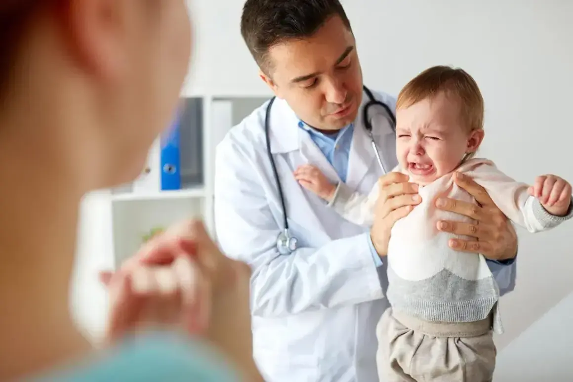 Lekarz uspokaja płaczące dziecko, które przechodzi skok rozwojowy. Jak sobie radzić z trudnymi emocjami malucha?