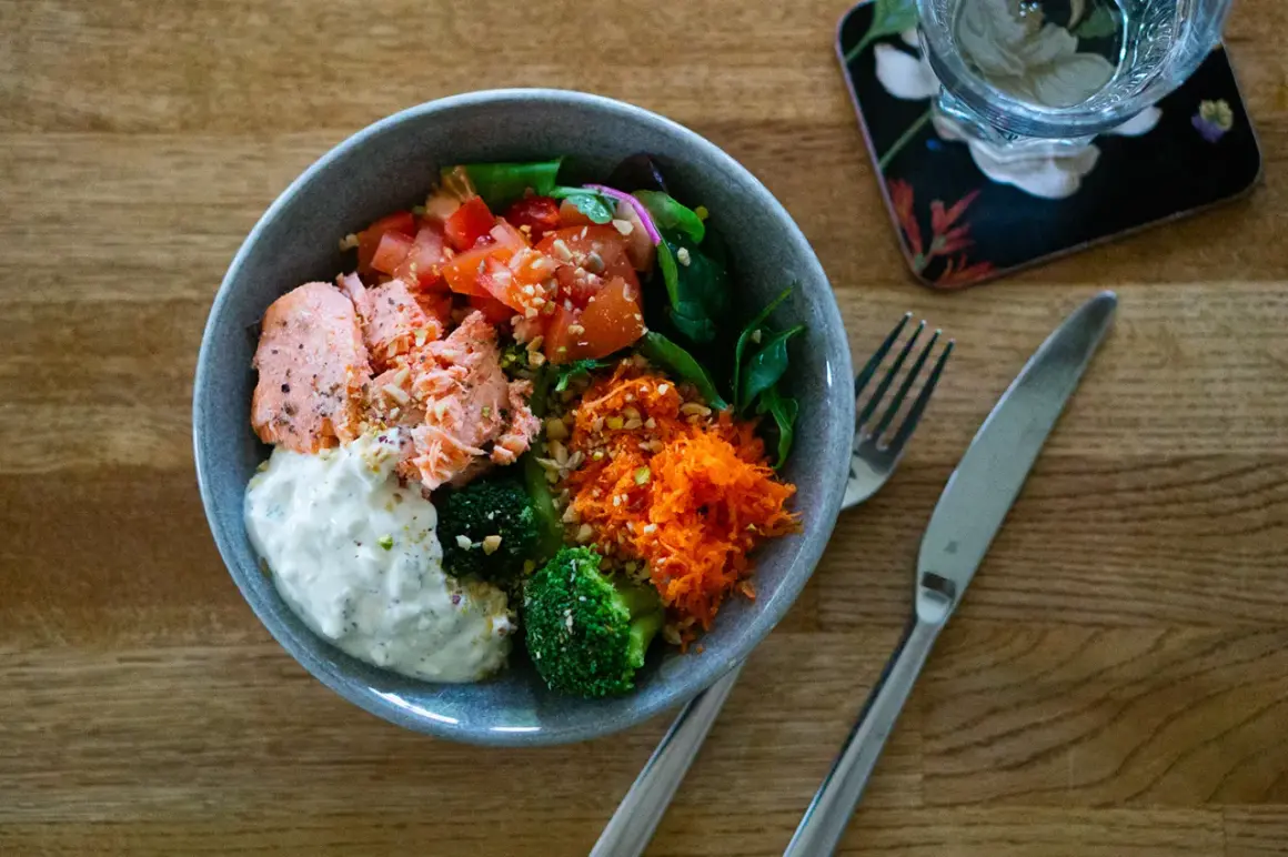 En härlig poke bowl med lax, broccoli, tomat och rivna morötter. Ett perfekt poke bowl recept för en hälsosam lunch.
