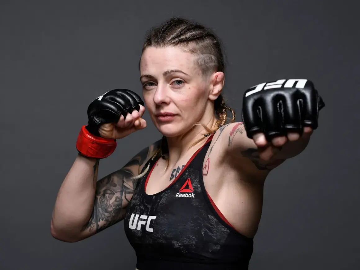 Joanne Calderwood, en MMA-fighter med flätor och tatueringar, visar upp sina boxningshandskar redo för strid.