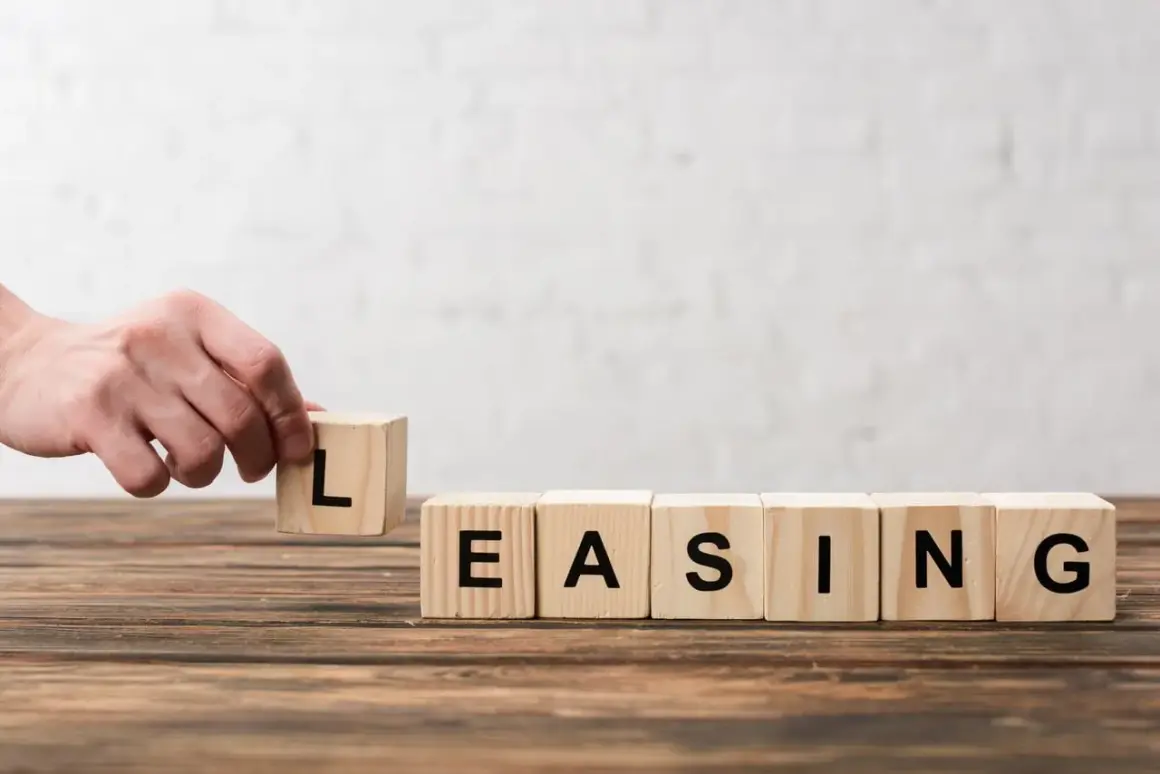 Dłoń układa kostkę z literą "L", tworząc słowo "LEASING". Zastanawiasz się, czy leasing się opłaca?