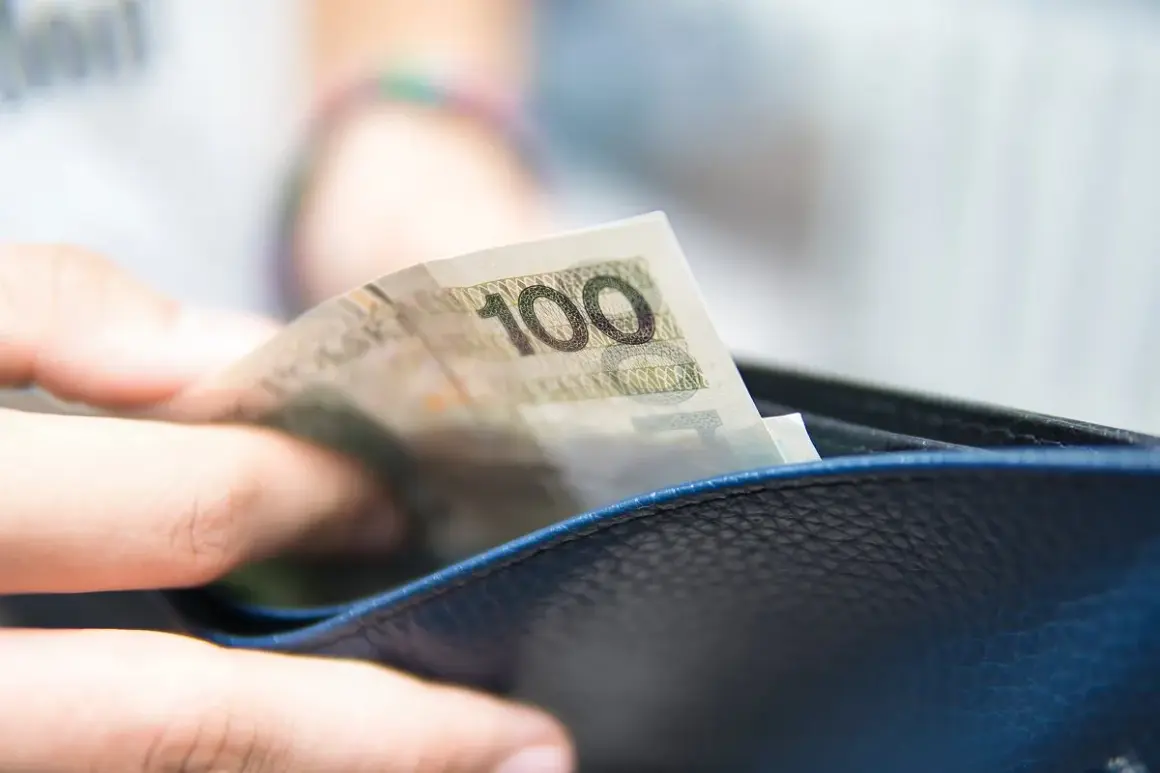 Dłoń wkłada banknot 100 zł do portfela. To może być część realizacji obowiązku alimentacyjnego.