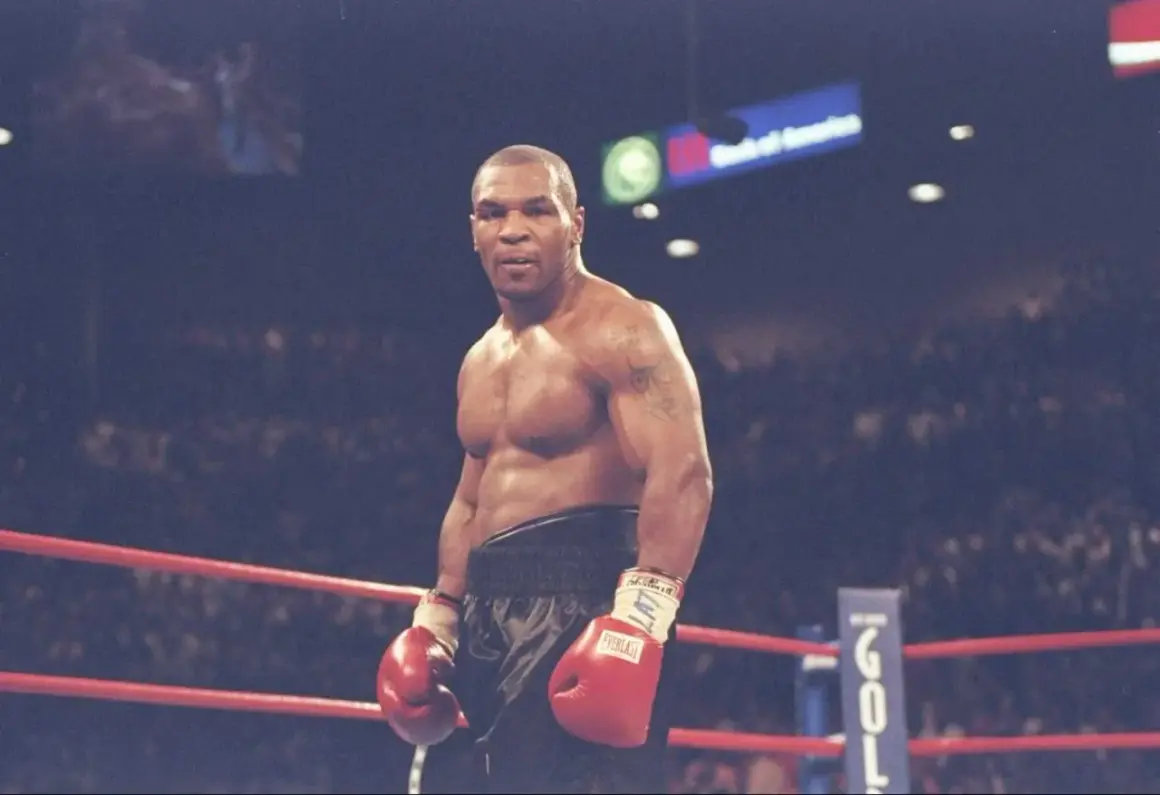 Mike Tyson in the ring, ready to fight. His intense gaze hints at the dedication required to train, making one wonder how long did Mike Tyson train a day to achieve such power.