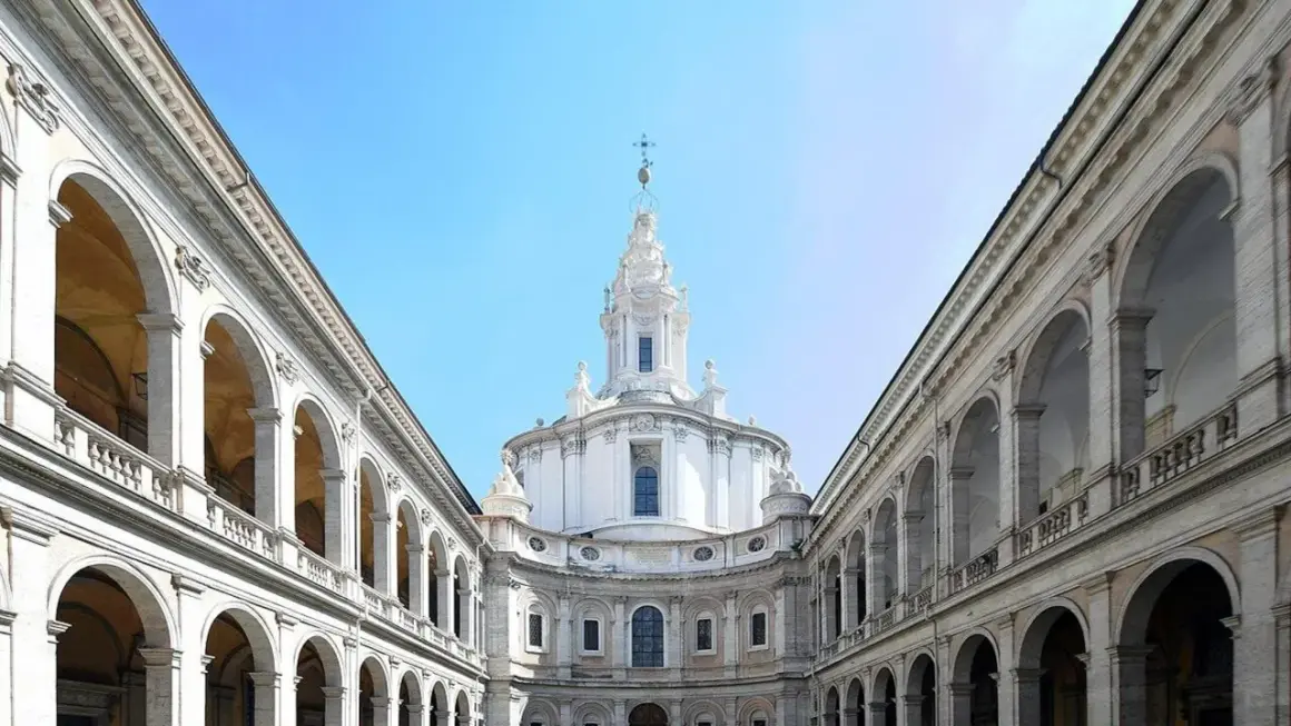 La chiesa della Sapienza a Roma, con la sua maestosa cupola e i portici ad arcate, incanta sotto un cielo azzurro.