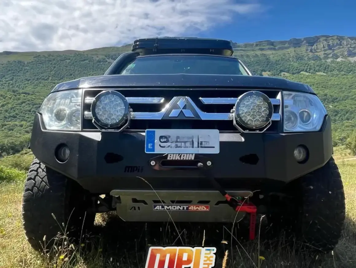 Mitsubishi Montero V80 preparado para aventura, con parachoques reforzado, focos potentes y techo solar.
