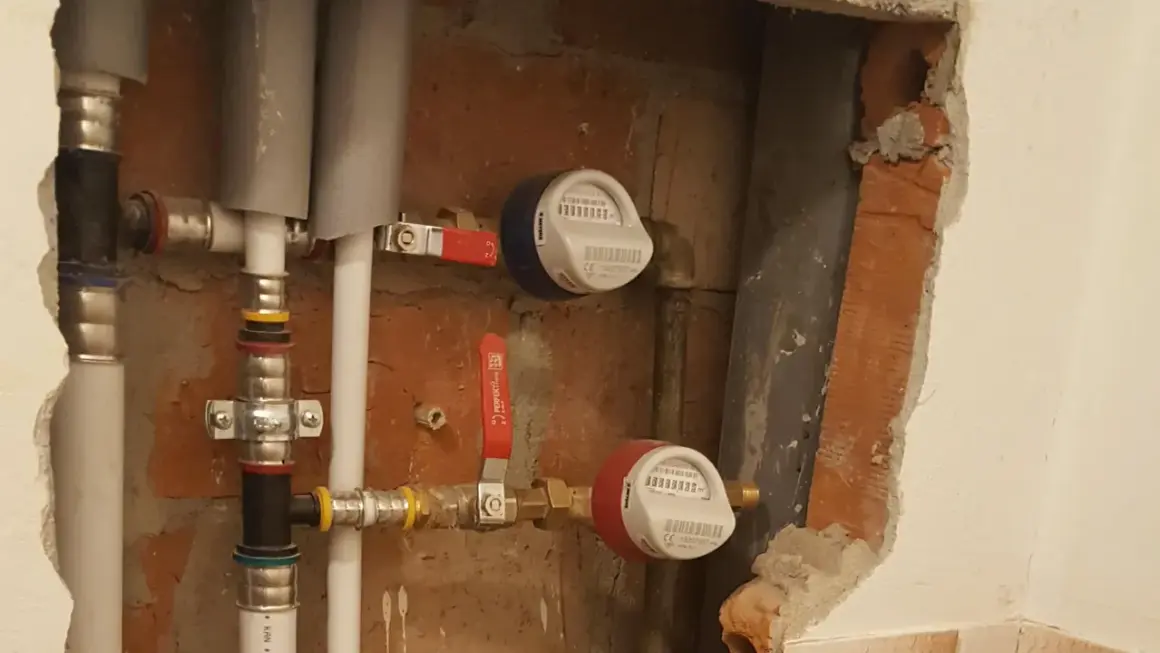 Instalacja wodna z dwoma wodomierzami i zaworami. To jest właśnie armatura, która pozwala kontrolować przepływ wody.