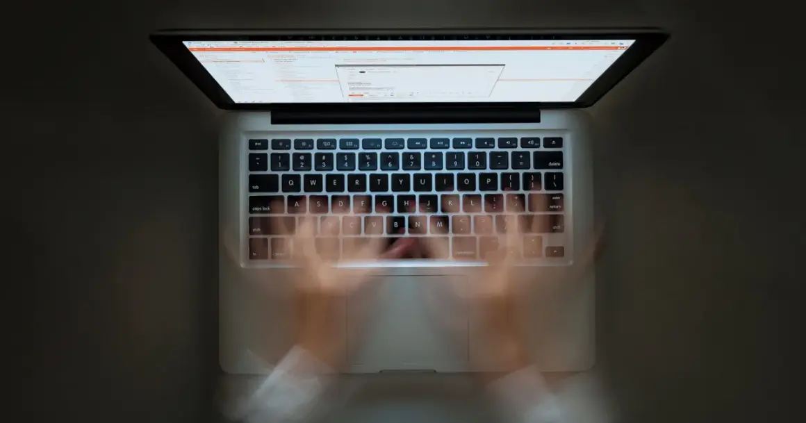 Ręce szybko piszą na klawiaturze laptopa. Widać ekran z kodem. Szybkie pisanie to jak zaznacz wszystko skrót.