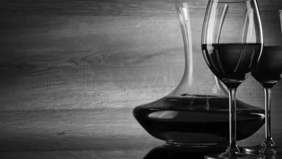 Caraffa e due calici di vino rosso, con un'atmosfera che evoca un buon cannellino di Frascati.