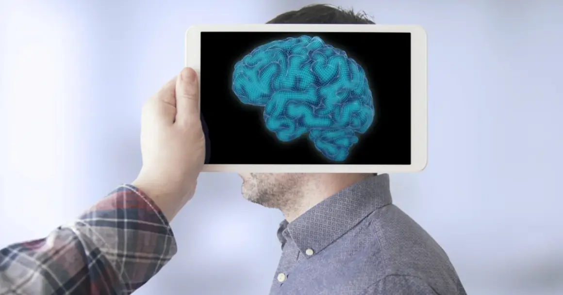 Dłoń trzyma tablet z cyfrowym mózgiem, sugerując analizę poziomów IQ.