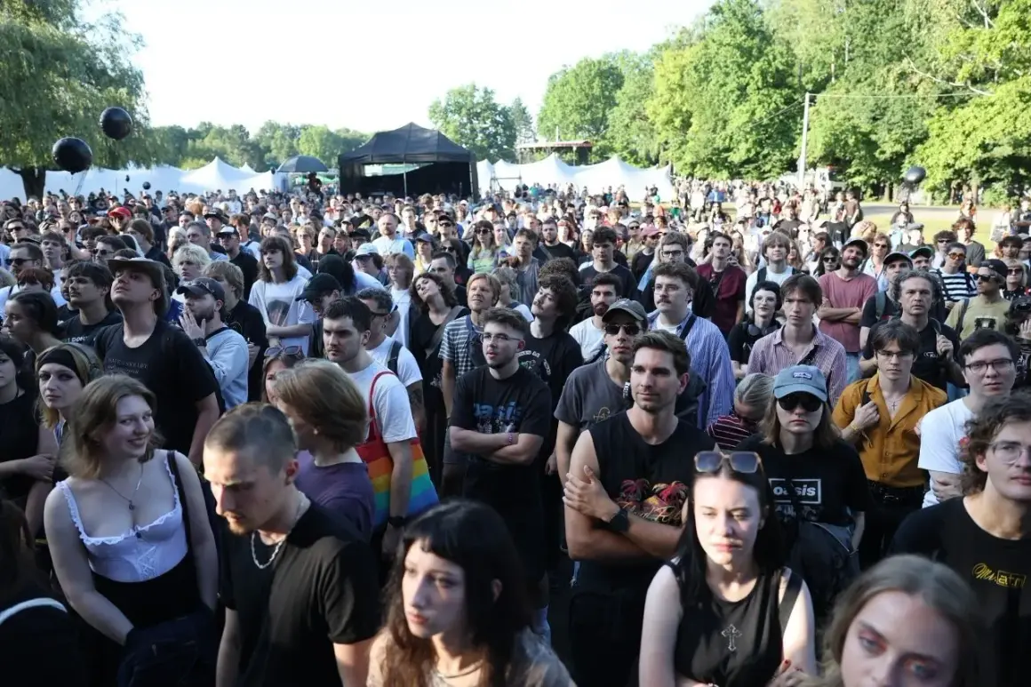 Tłum ludzi na koncercie w Katowicach. Słońce, drzewa i namioty festiwalowe w tle. Atmosfera festiwalu Katowice Off Festival.