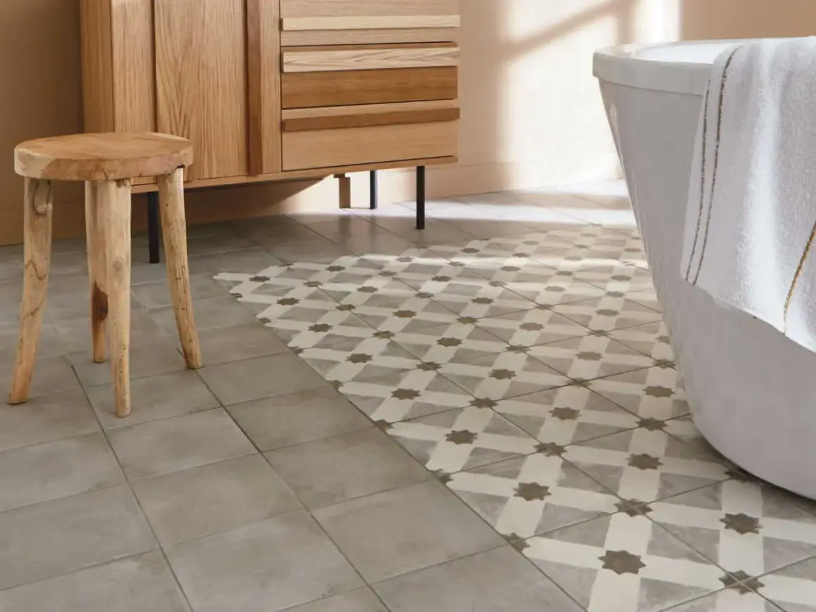 Un sol de salle de bain avec deux types de carrelage : un uni gris et un à motifs géométriques. Une idée pour peindre carrelage sol et moderniser une pièce.