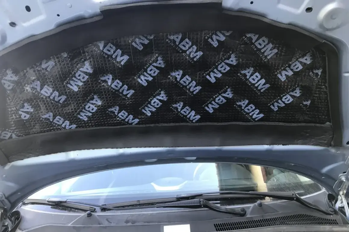 Mata pod maskę samochodu z logo ABM, poprawiająca komfort akustyczny.