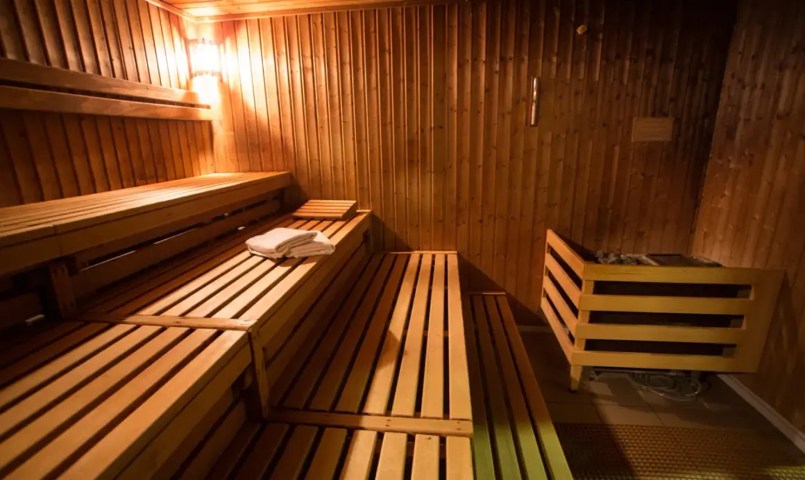 Drewniane ławy i kamienny piec w przytulnej czeskiej saunie. Czeska sauna co to? To relaks i gorąco!