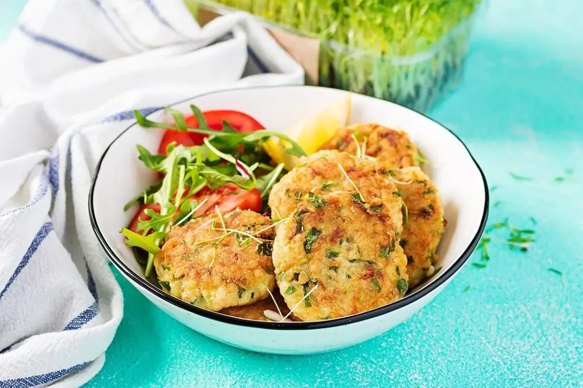 Croquetas de atún doradas y crujientes, servidas con una ensalada fresca de rúcula y tomate, y un toque de limón.