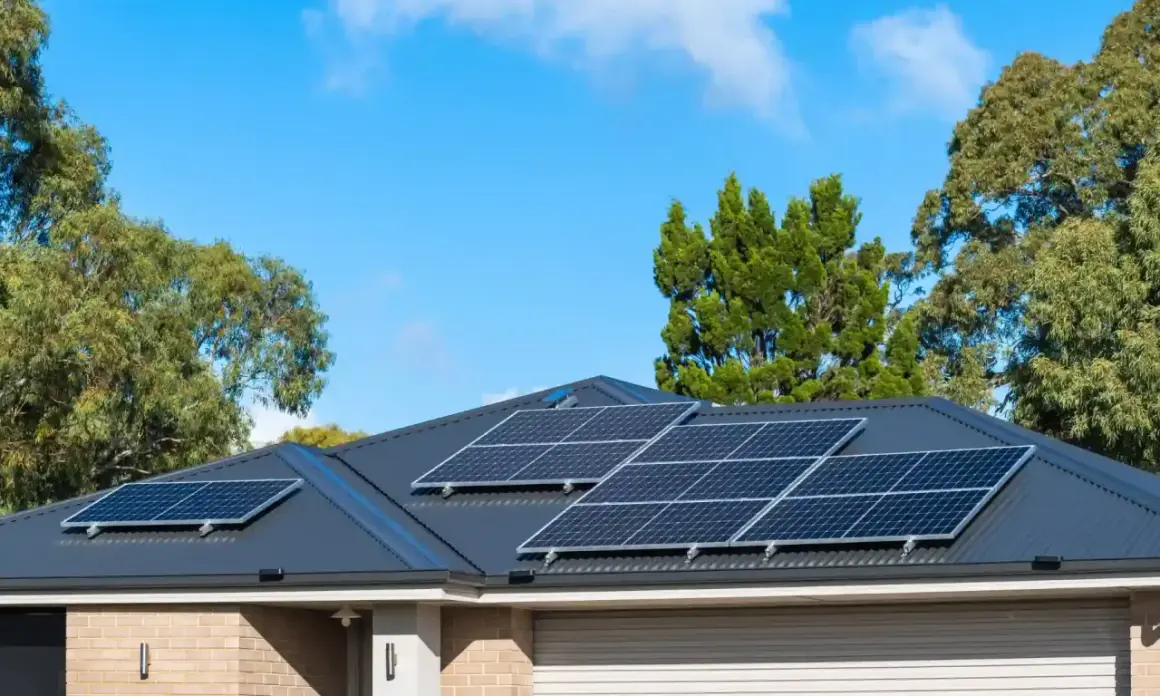 Pannelli solari sul tetto di una casa, con alberi sullo sfondo. Si valuta il collegamento pannelli solari in serie o parallelo per massimizzare l'energia.