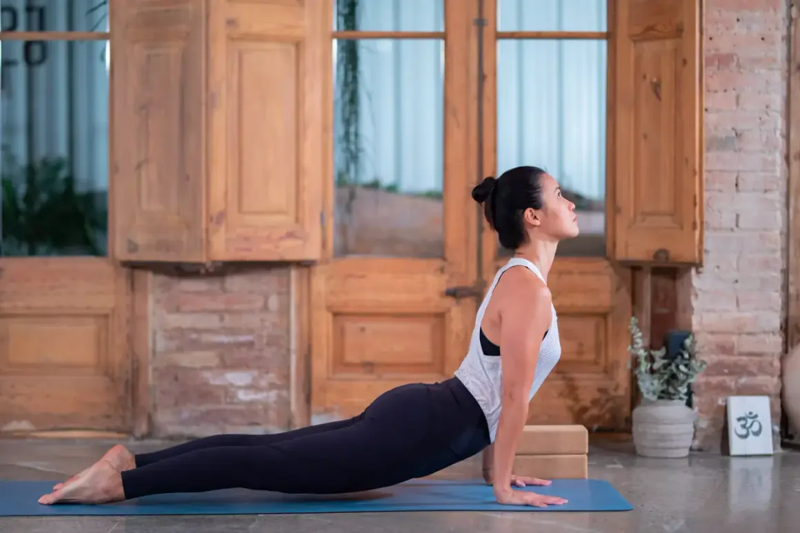 Mujer en postura de cobra, parte de un vinyasa flow yoga que es una secuencia fluida de posturas.
