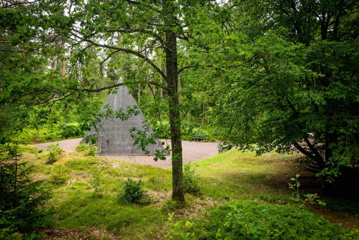 En grå pyramid reser sig ur en lummig skog. En perfekt plats för udda utflykter i Småland, med bänkar för vila.